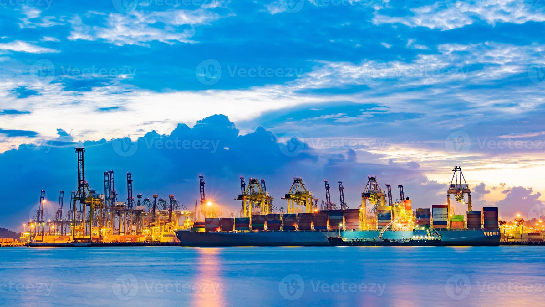 buque carguero cargando carga en el muelle de carga en el crepúsculo. Singapur, sudeste asiático. foto