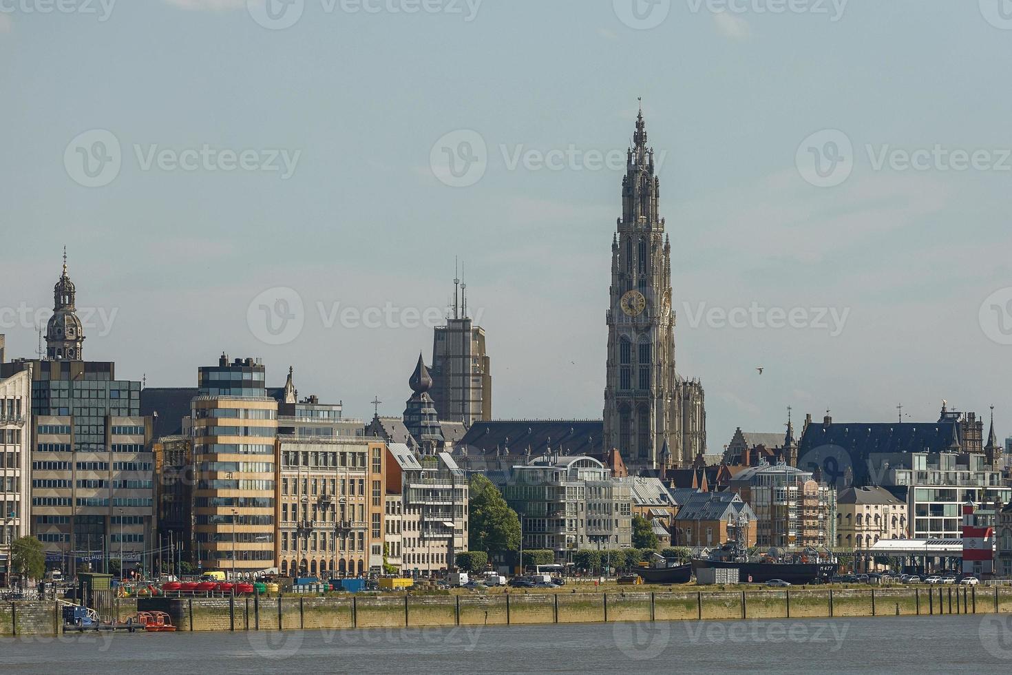 Cityscape of a port of Antwerp and cathedral of our lady in Belgium over the river photo