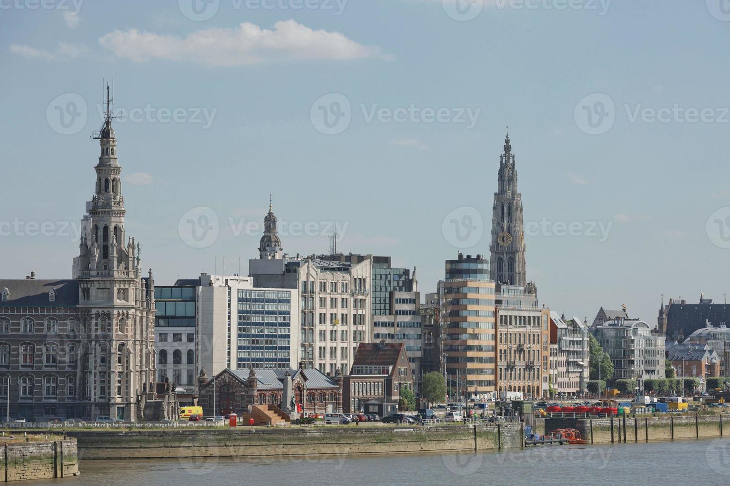 Cityscape of a port of Antwerp and cathedral of our lady in Belgium over the river photo