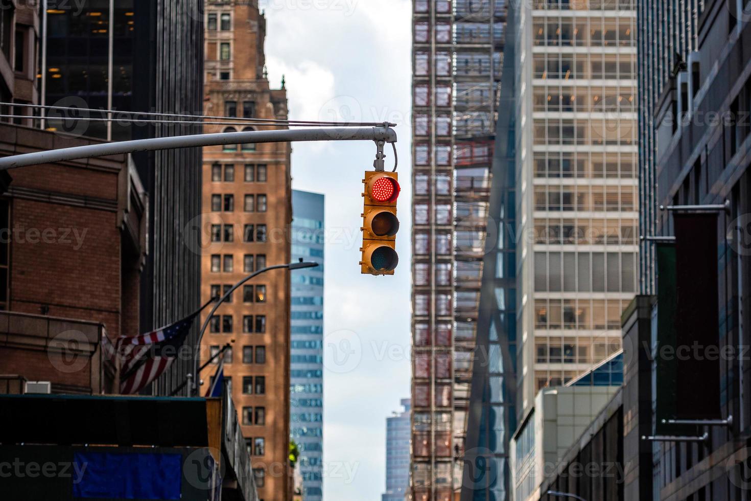 Semáforo con luz roja sobre la calle Manhatan entre muchos rascacielos foto