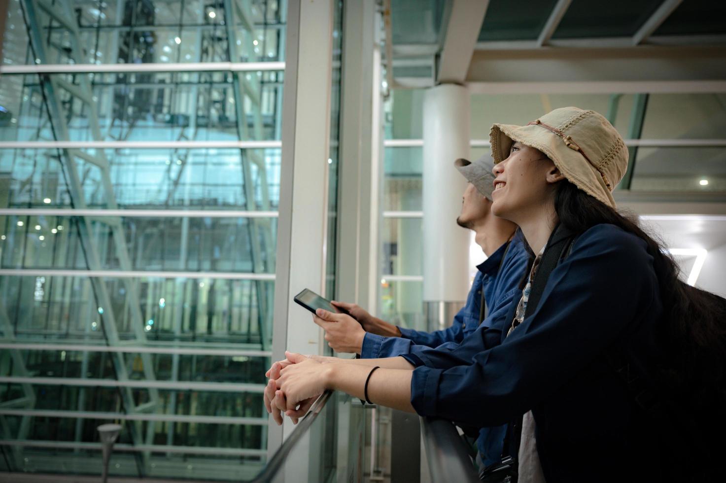 traveler couple person travel at aerodrome with baggage, journey vacation trip with man and woman, flight transportation arrival waiting in airport terminal photo