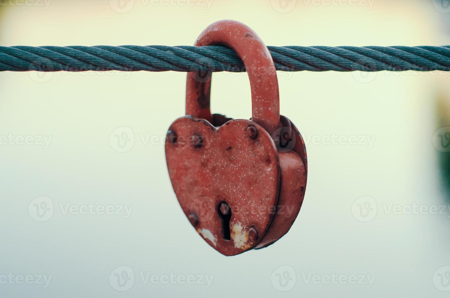 Red peeling wedding lock on a rope with a key hole photo