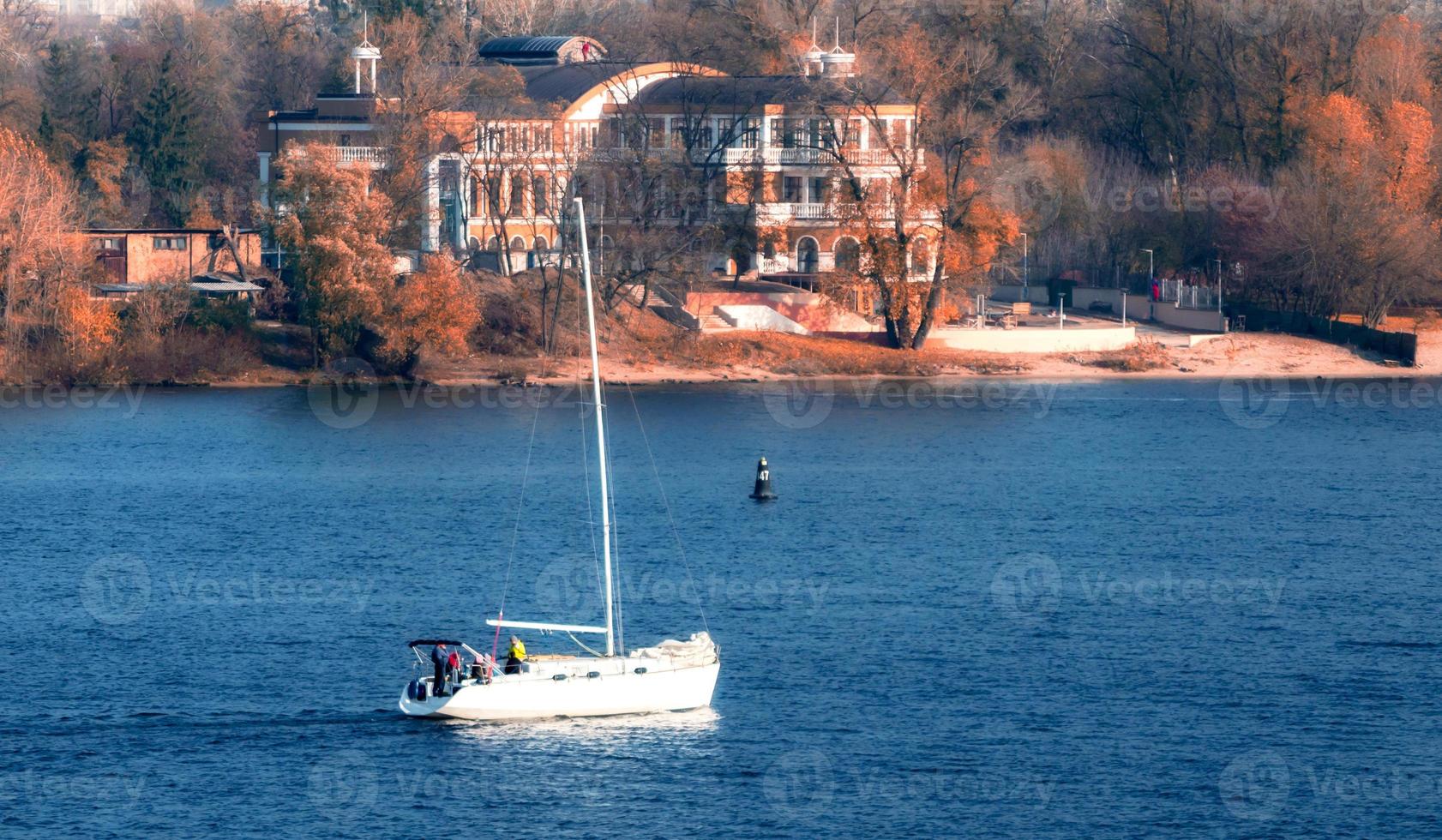 yate en el fondo de la costa y la ciudad. foto