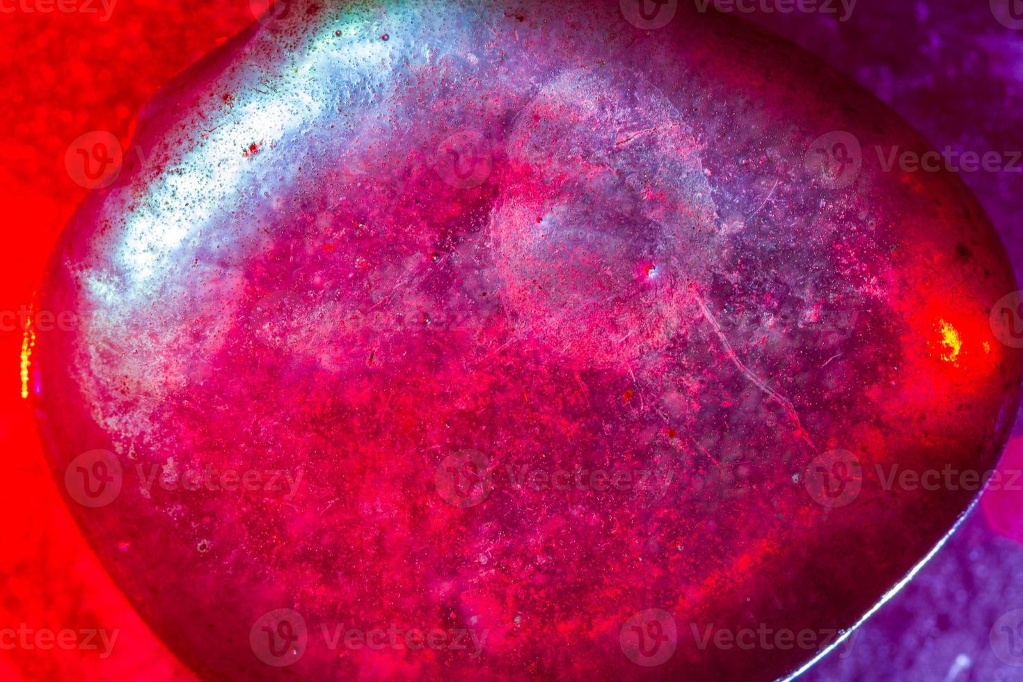 Mineral gem colorfully illuminated in macro capture showing abstract space type details photo