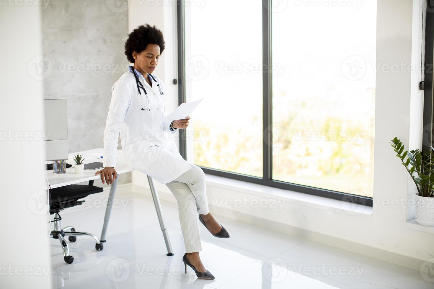 Doctor sitting on the edge of a desk photo