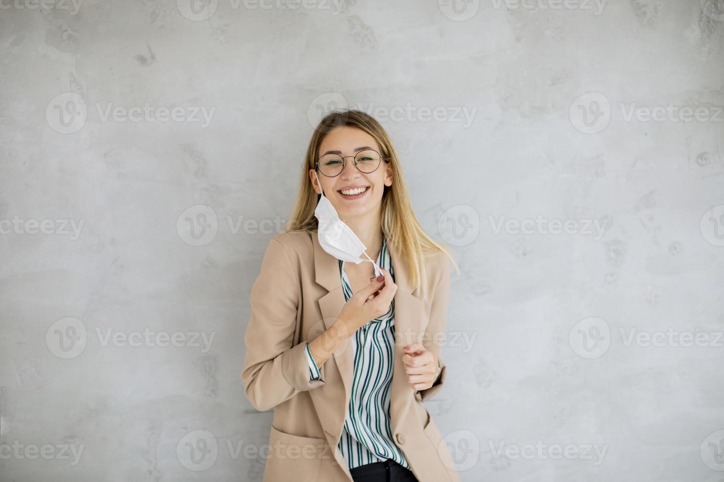 mujer joven, quitarse, máscara foto