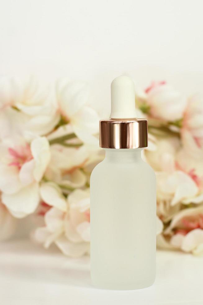 Cosmetic bottle with flowers photo