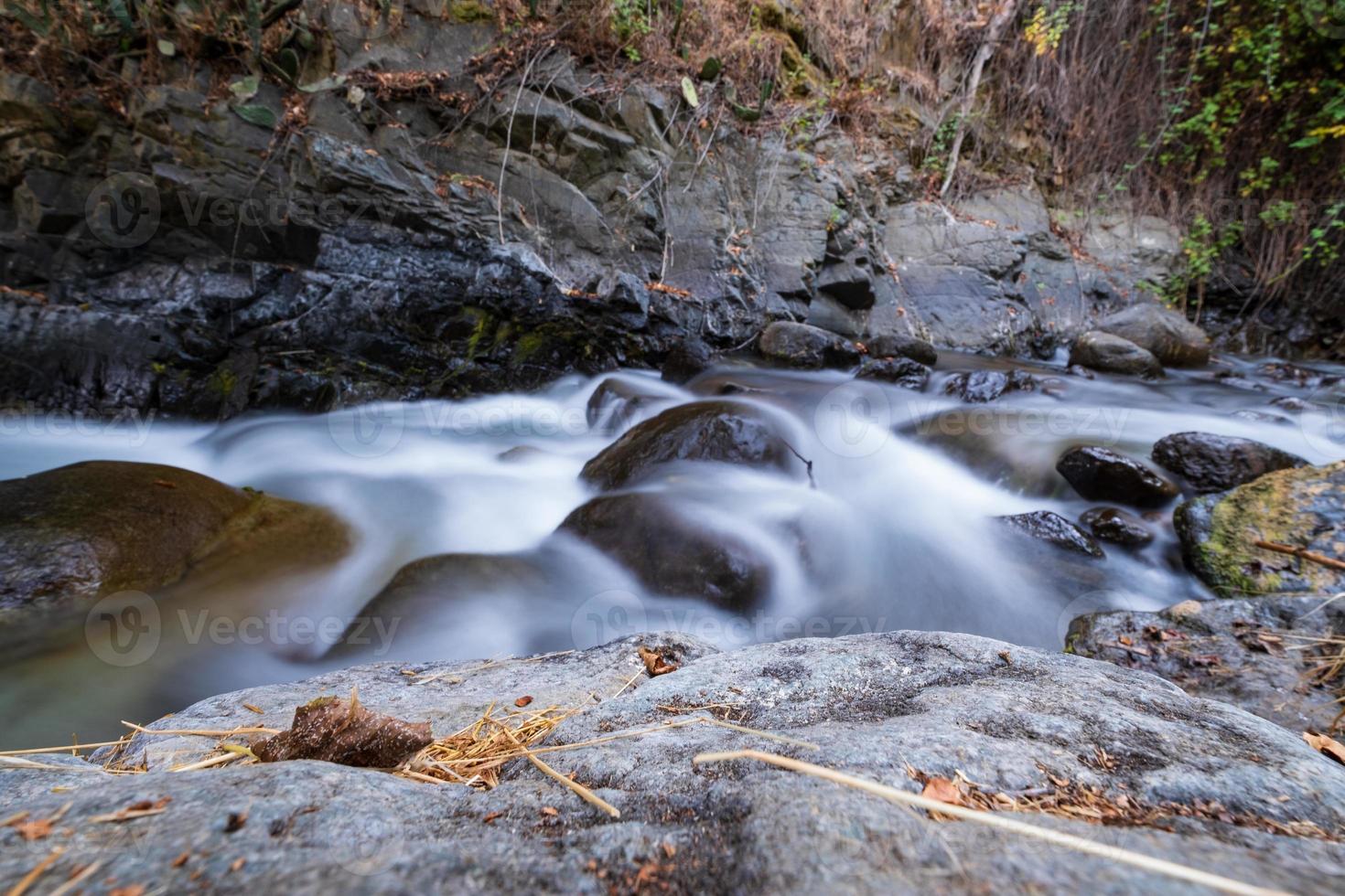 Corriente de agua pura con flujo suave sobre terreno montañoso rocoso en el bosque de Kakopetria en Troodos Chipre foto