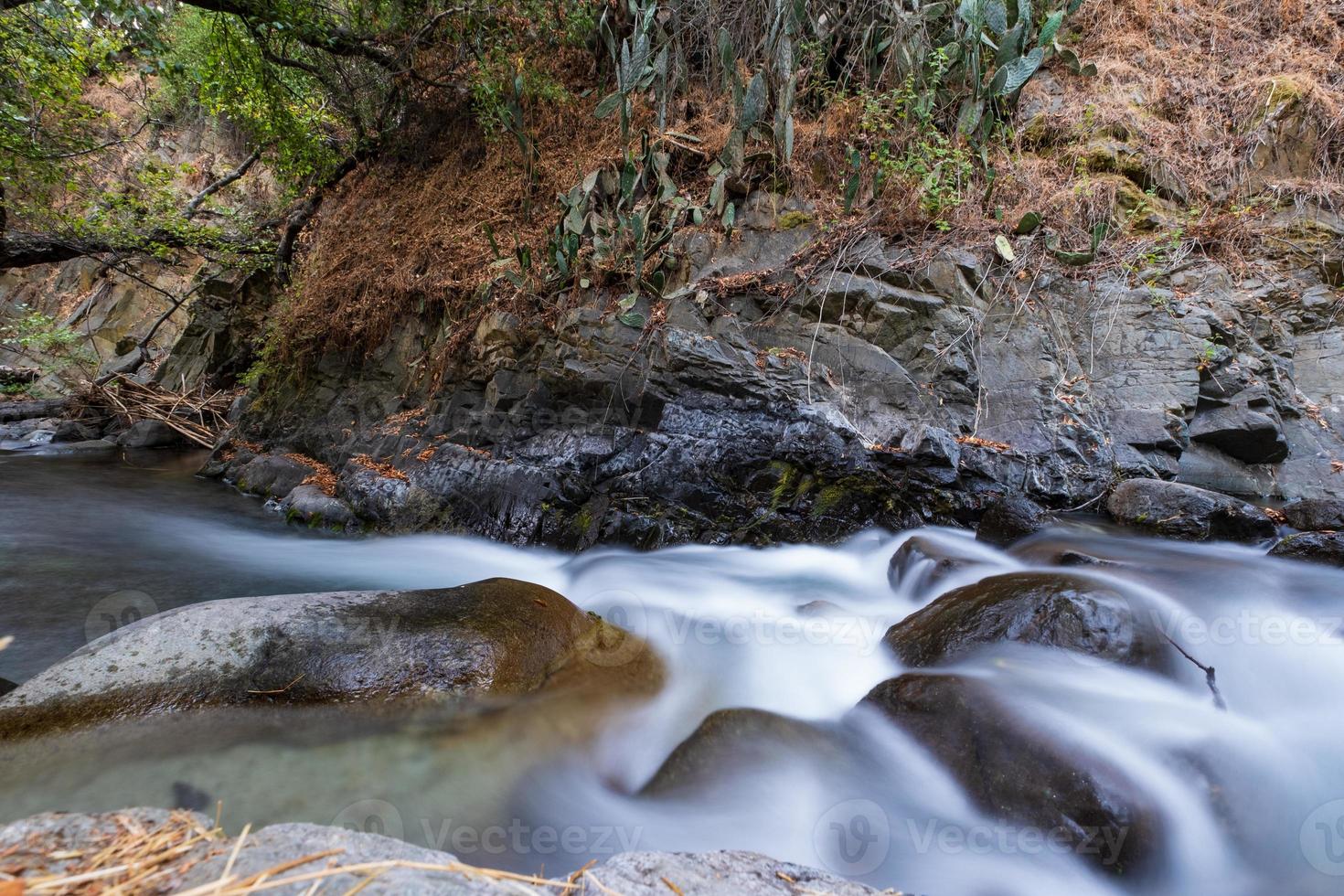 Corriente de agua pura con flujo suave sobre terreno montañoso rocoso en el bosque de Kakopetria en Troodos Chipre foto