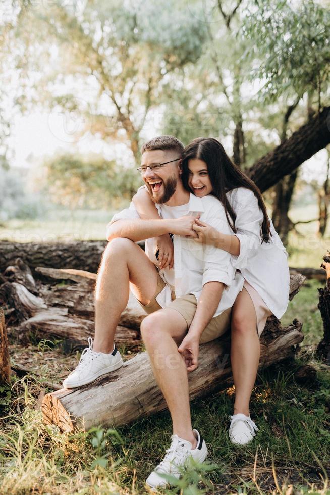 Pareja joven enamorada de un chico con barba y una chica de cabello oscuro con ropa clara foto