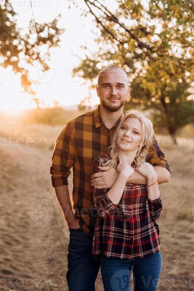 Cheerful guy with a board and a blonde girl for a walk in plaid shirts photo