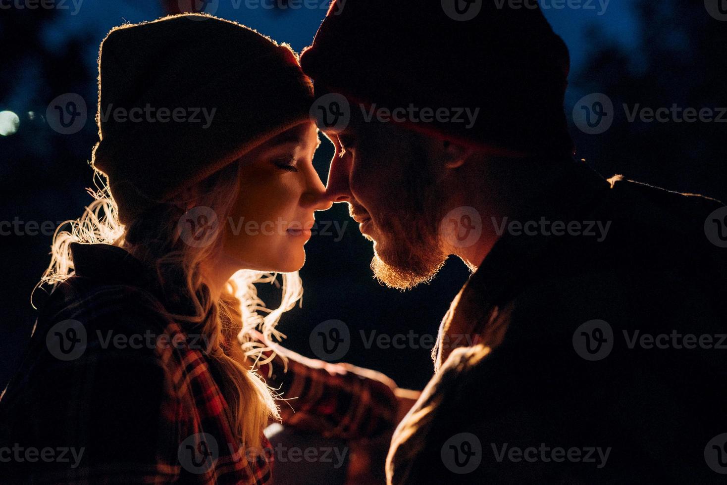 Pareja joven un chico y una chica con sombreros de punto brillantes se detuvieron en un camping foto