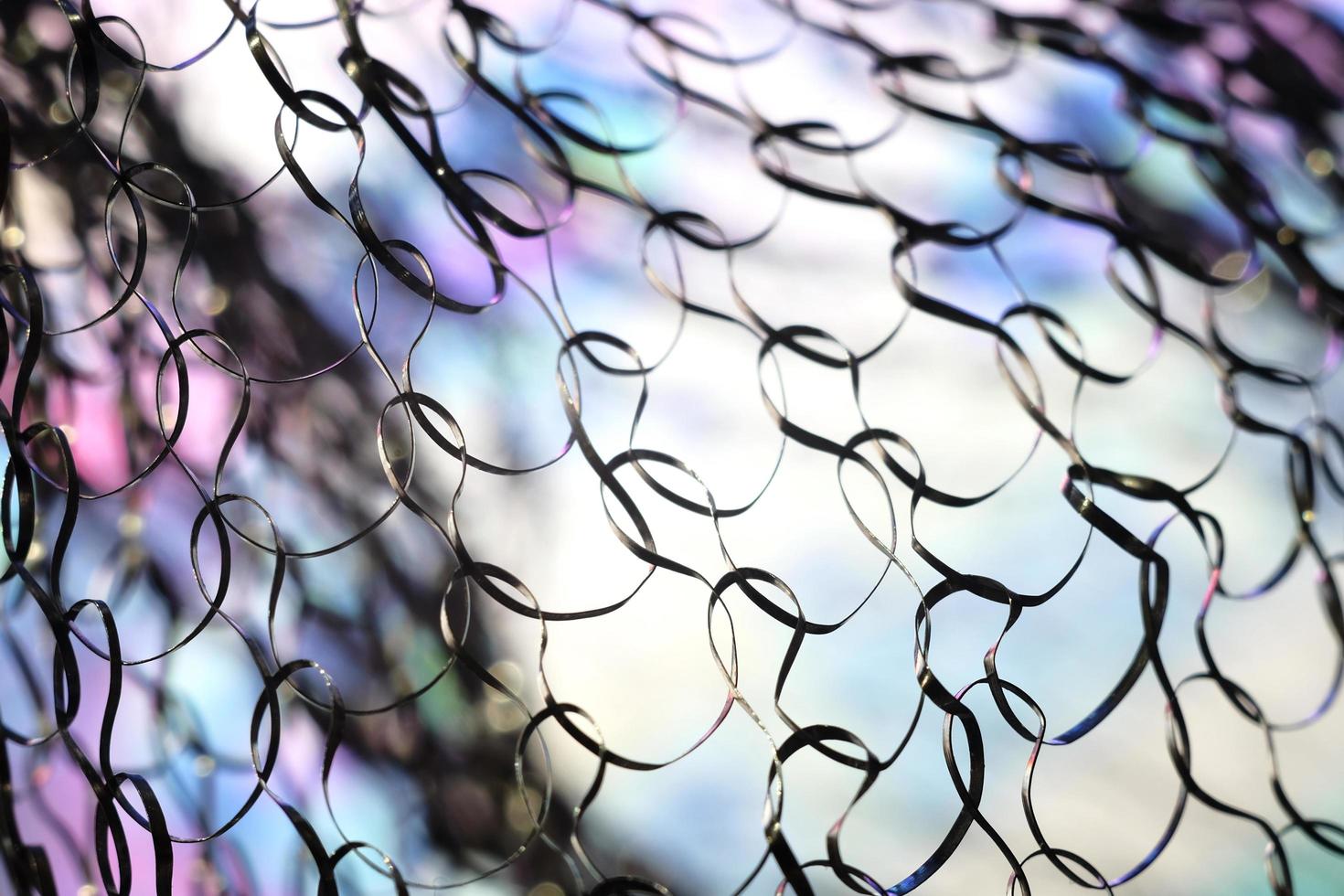 Close up image of a metal net with colorful abstract background photo