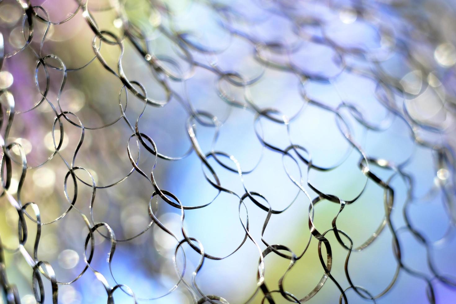 Close up image of a metal net with colorful abstract background photo