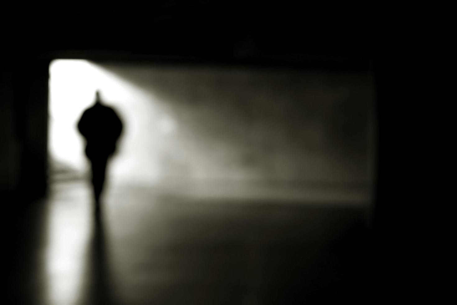 Una silueta humana borrosa en un pasaje subterráneo. foto