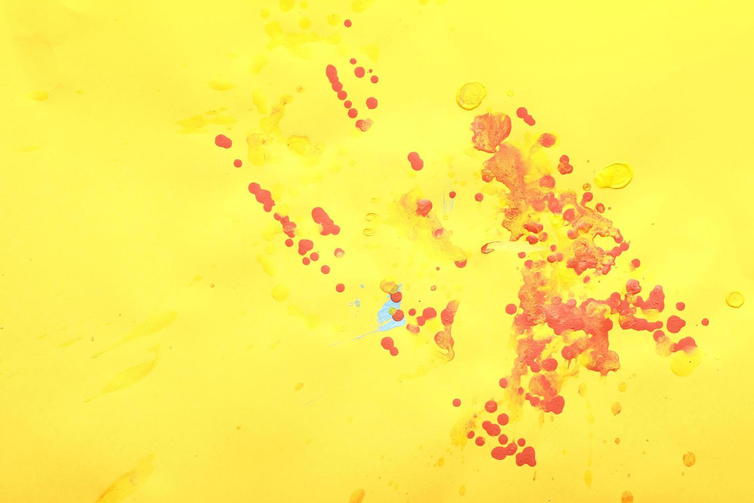 Red paint splashes on a yellow paper photo