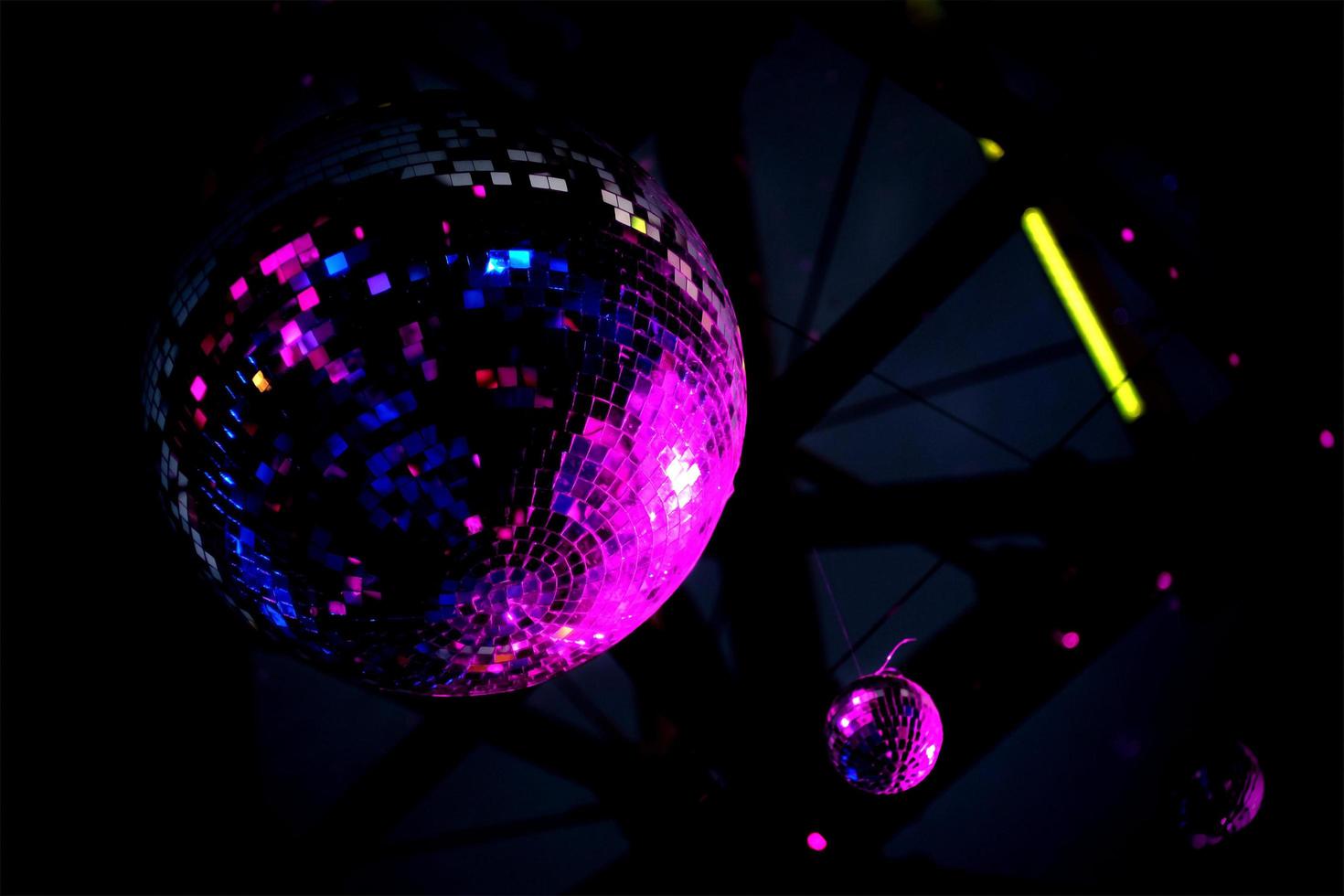 bola de discoteca reflejada en luz púrpura foto