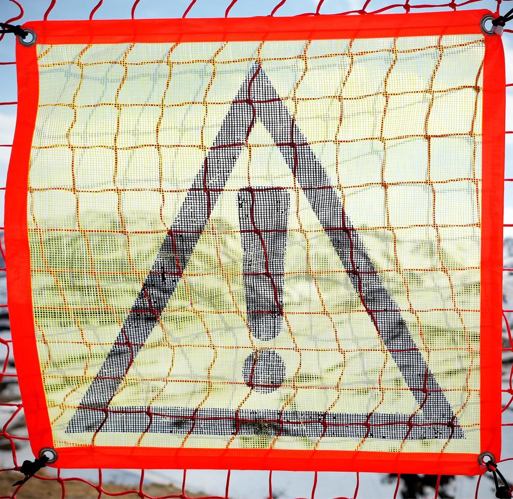 A yellow prohibition sign on a plastic net photo