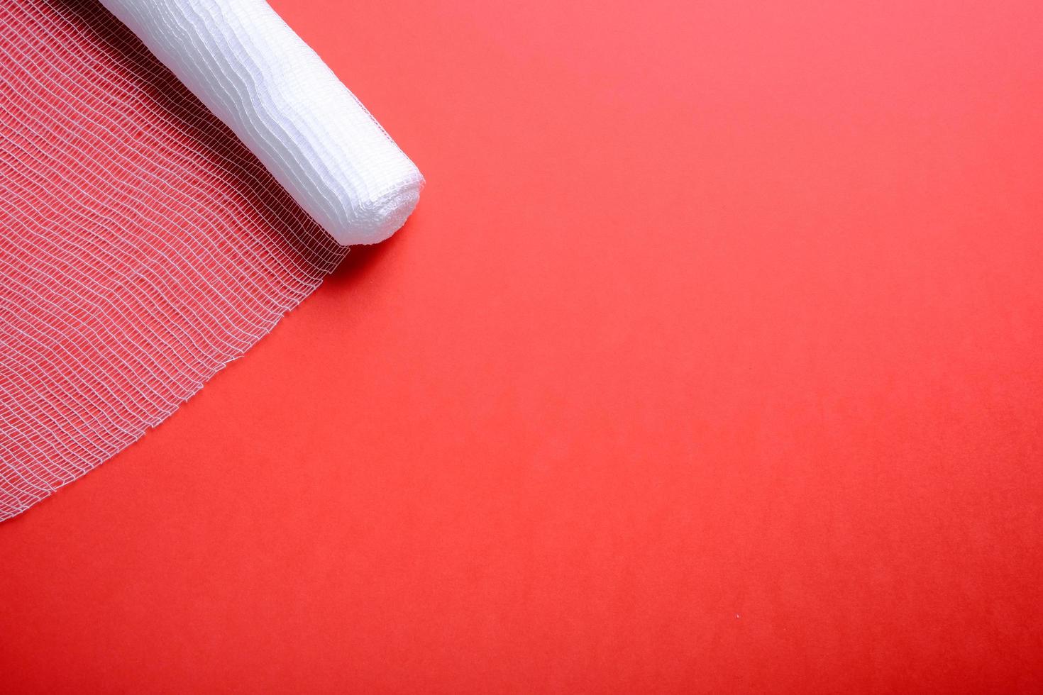 Sterile bandage on red background photo