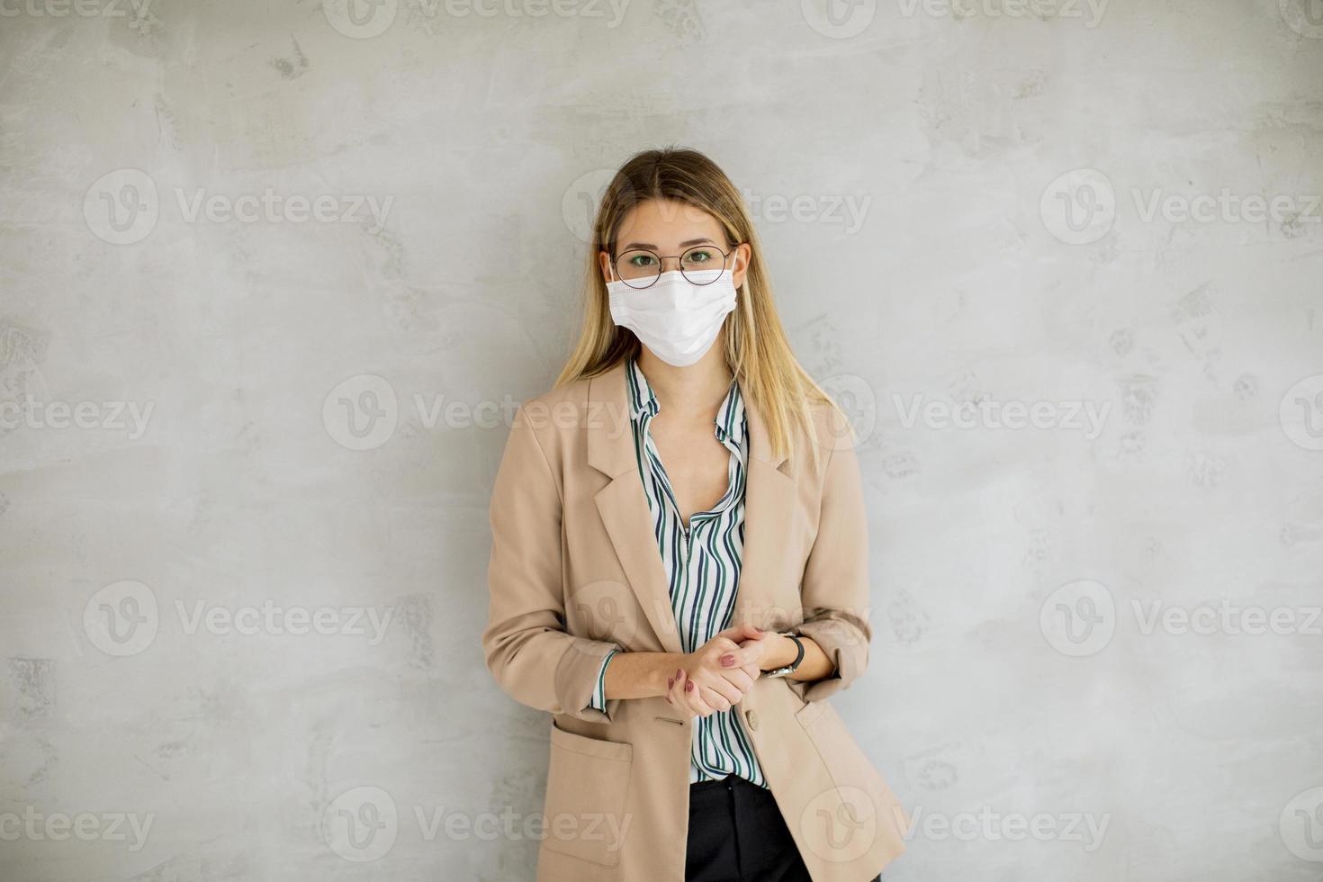 mujer recostada contra la pared y con una máscara foto