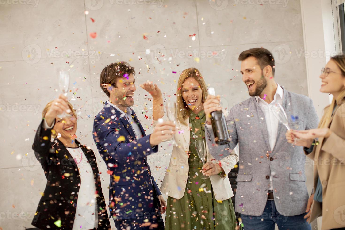 Group celebrating and toasting with confetti photo