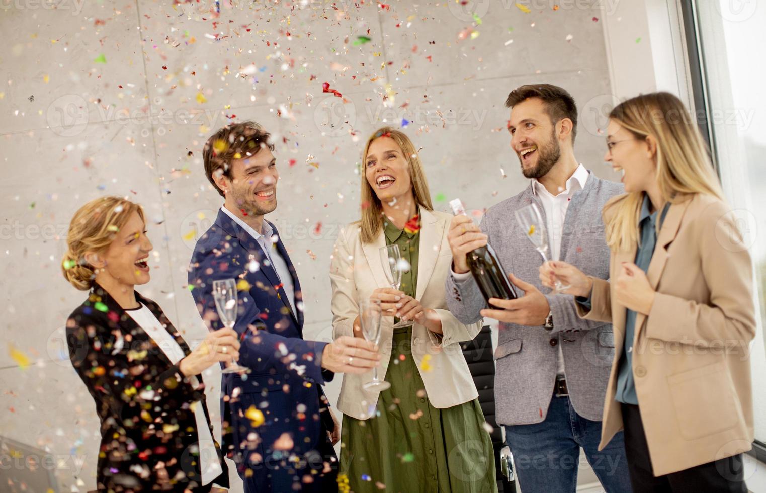 Professionals toasting with confetti falling photo