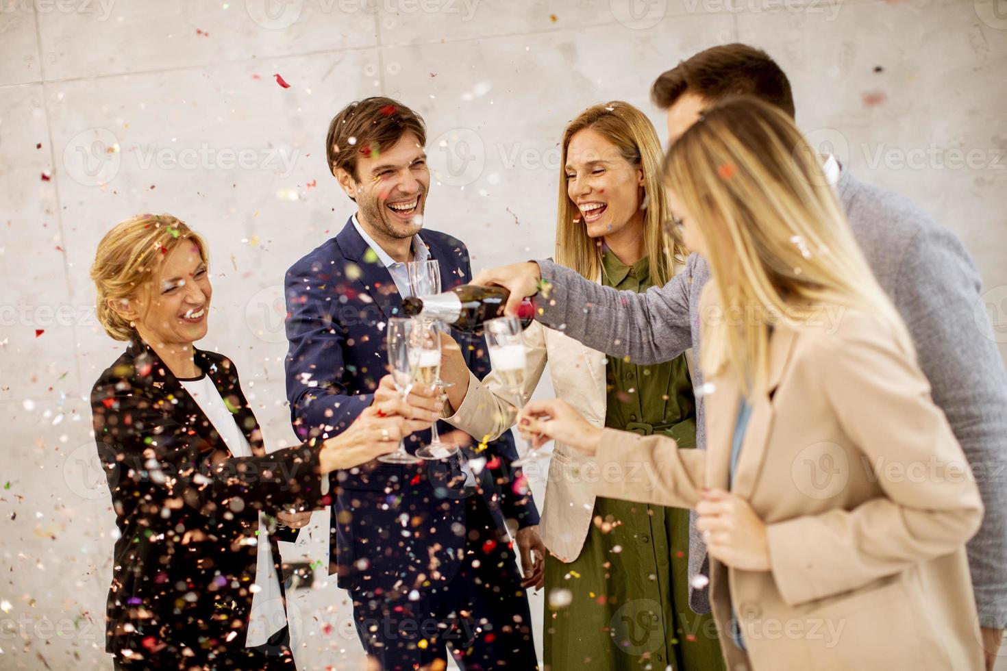 Group toasting with confetti falling photo