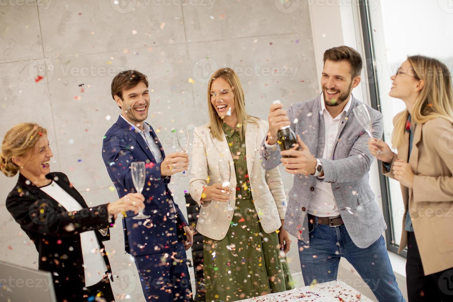 People toasting with confetti falling photo