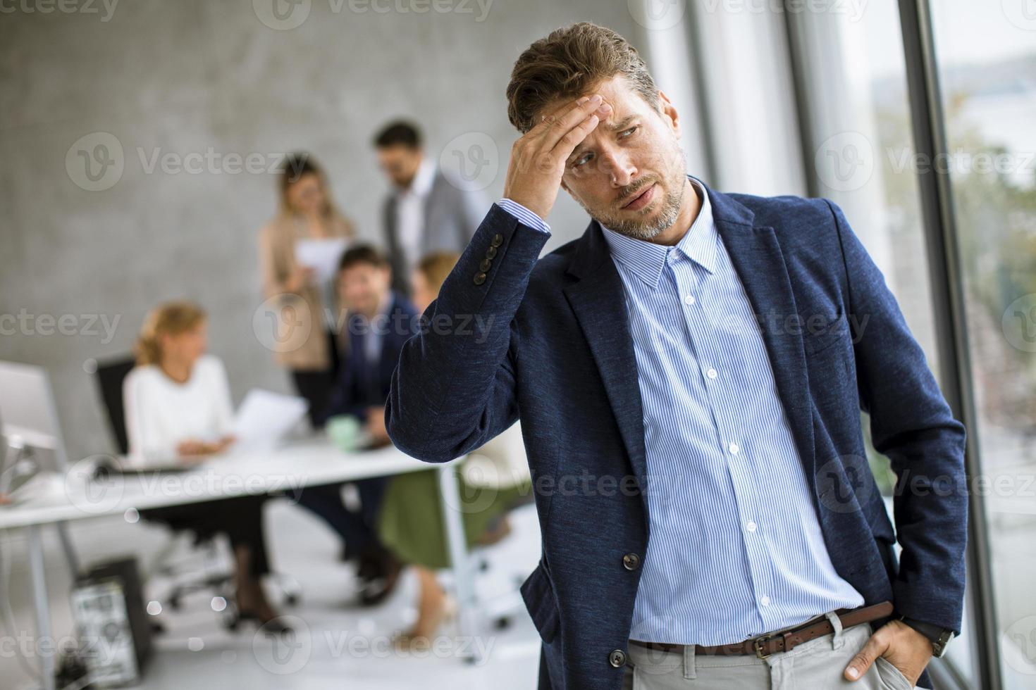 Exhausted man in front of team photo