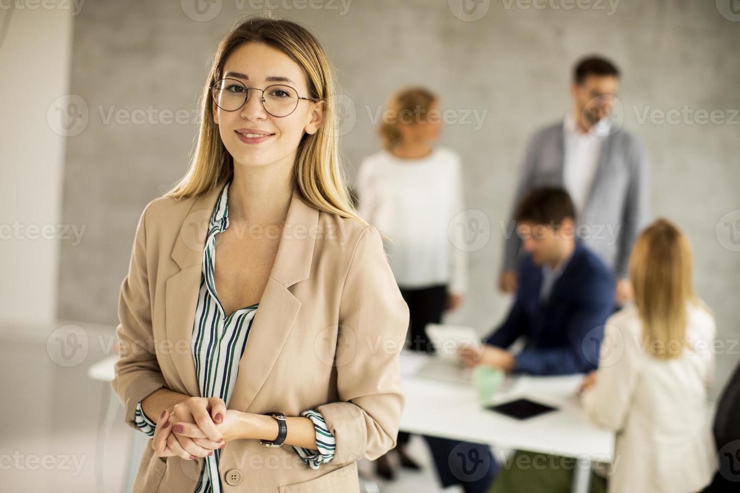 mujer con gafas frente a una reunión foto