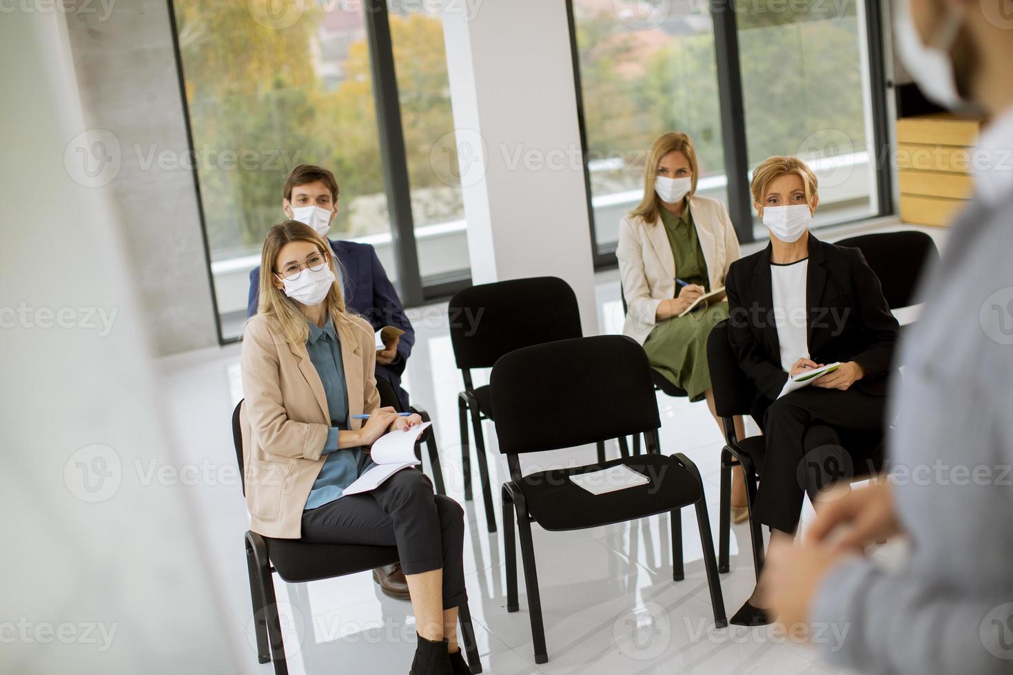 People in masks in a meeting photo