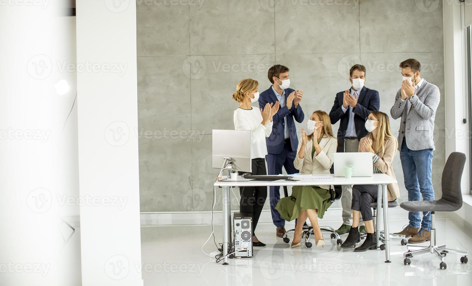 Group of masked professionals clapping photo