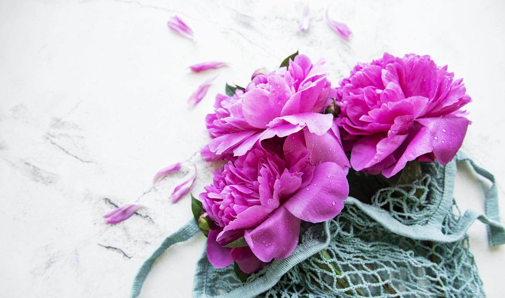 Pink peony flowers in string bag photo