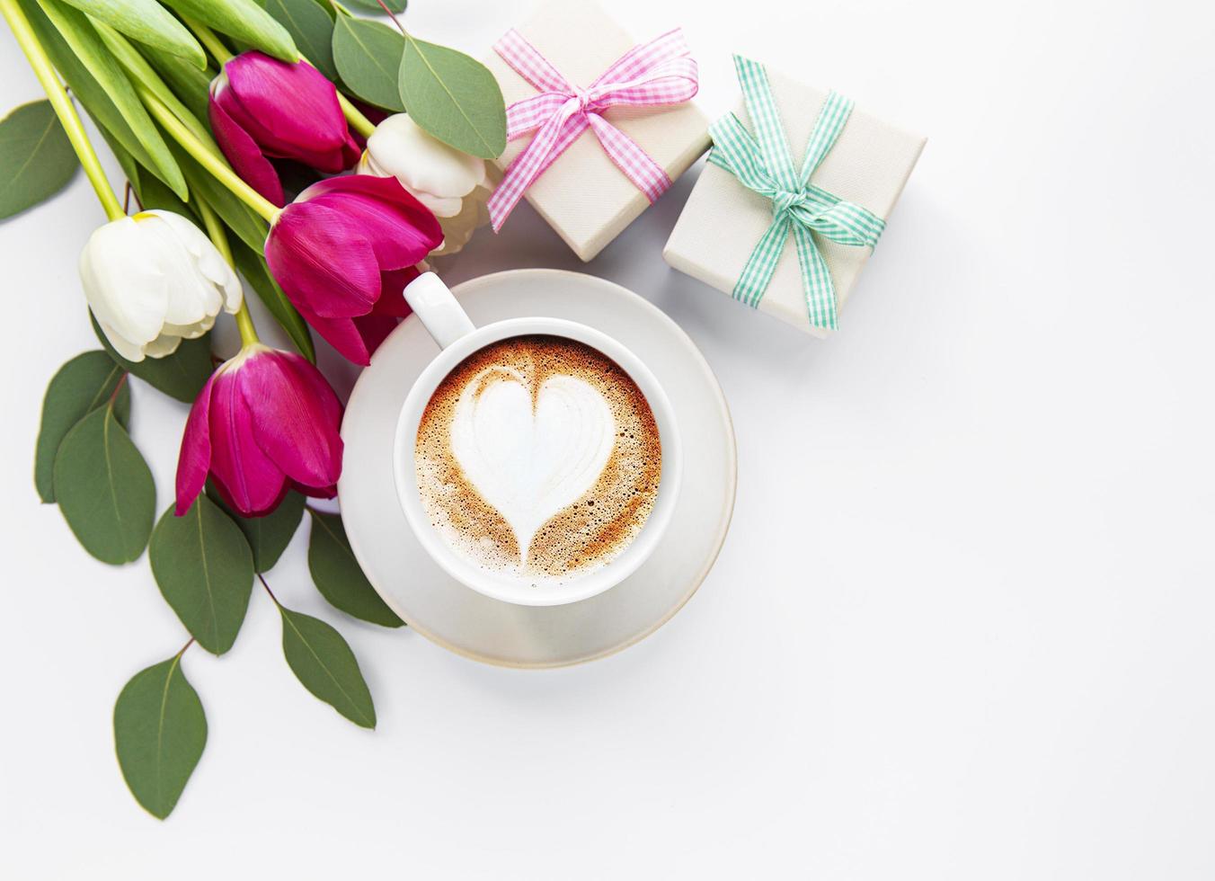 Coffee cup with latte art and tulips photo