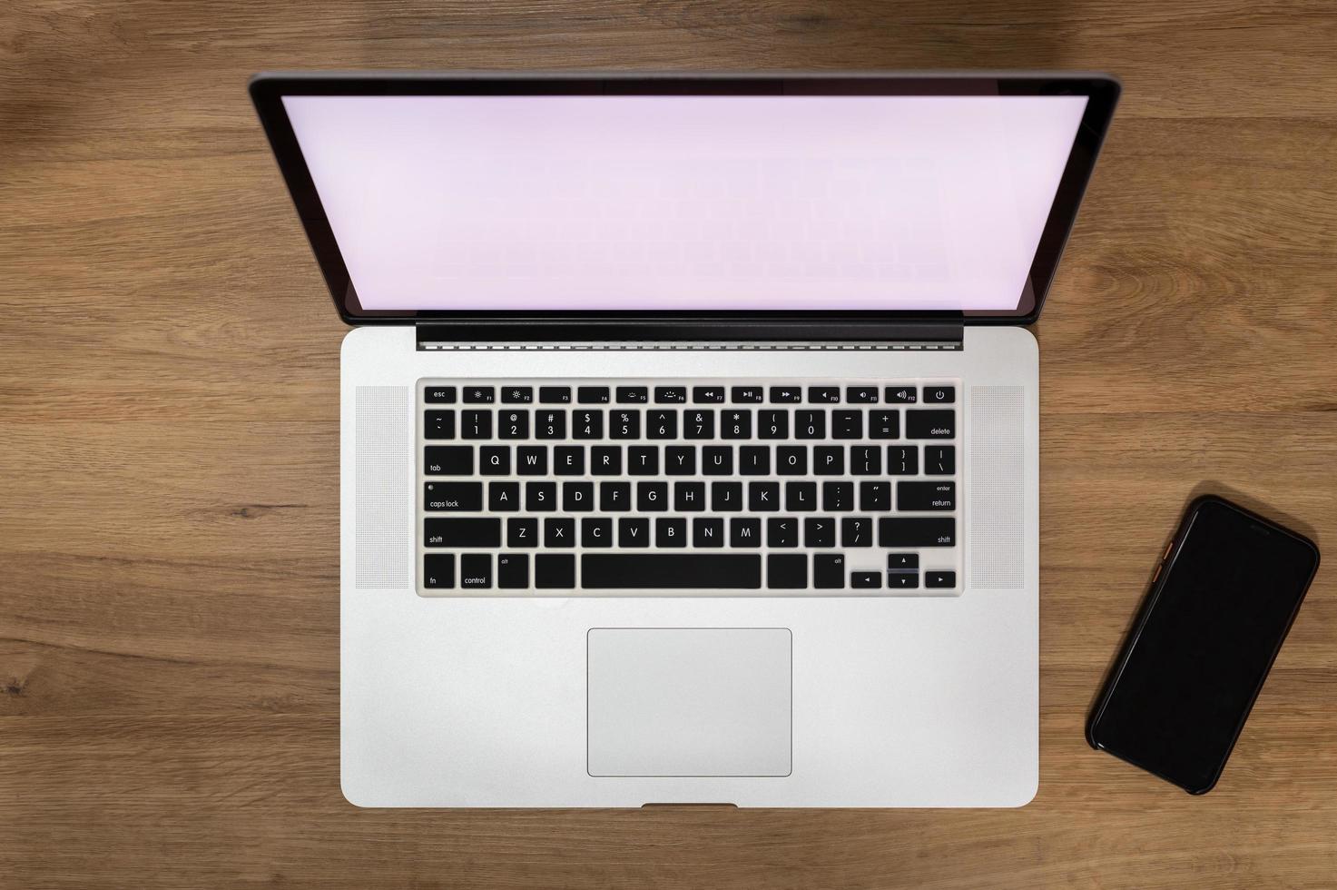 Blank screen of laptop computer with smartphone, top view photo