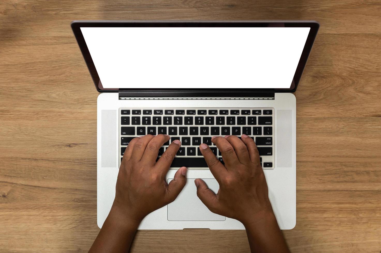 Top view of laptop computer with hands on wooden table photo