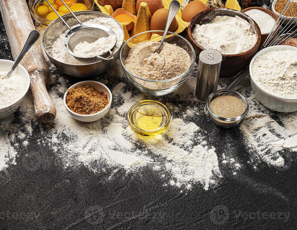 Baking ingredients on black background with copy space photo