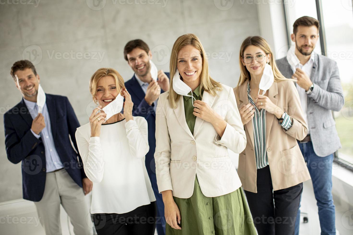 Group of professionals taking off masks photo