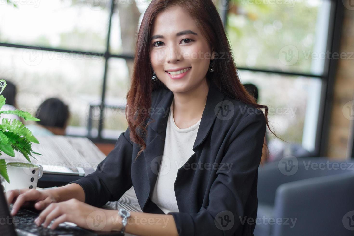 Mujeres de negocios asiáticas usando laptop en cafe foto