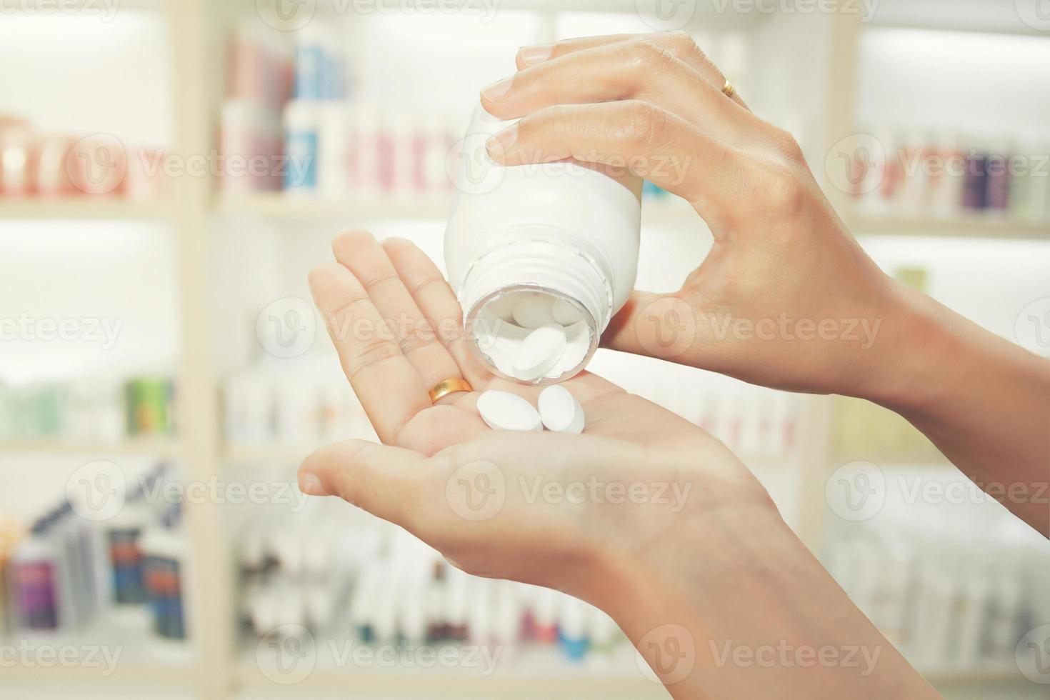 Person pouring pills out of medicine bottle photo