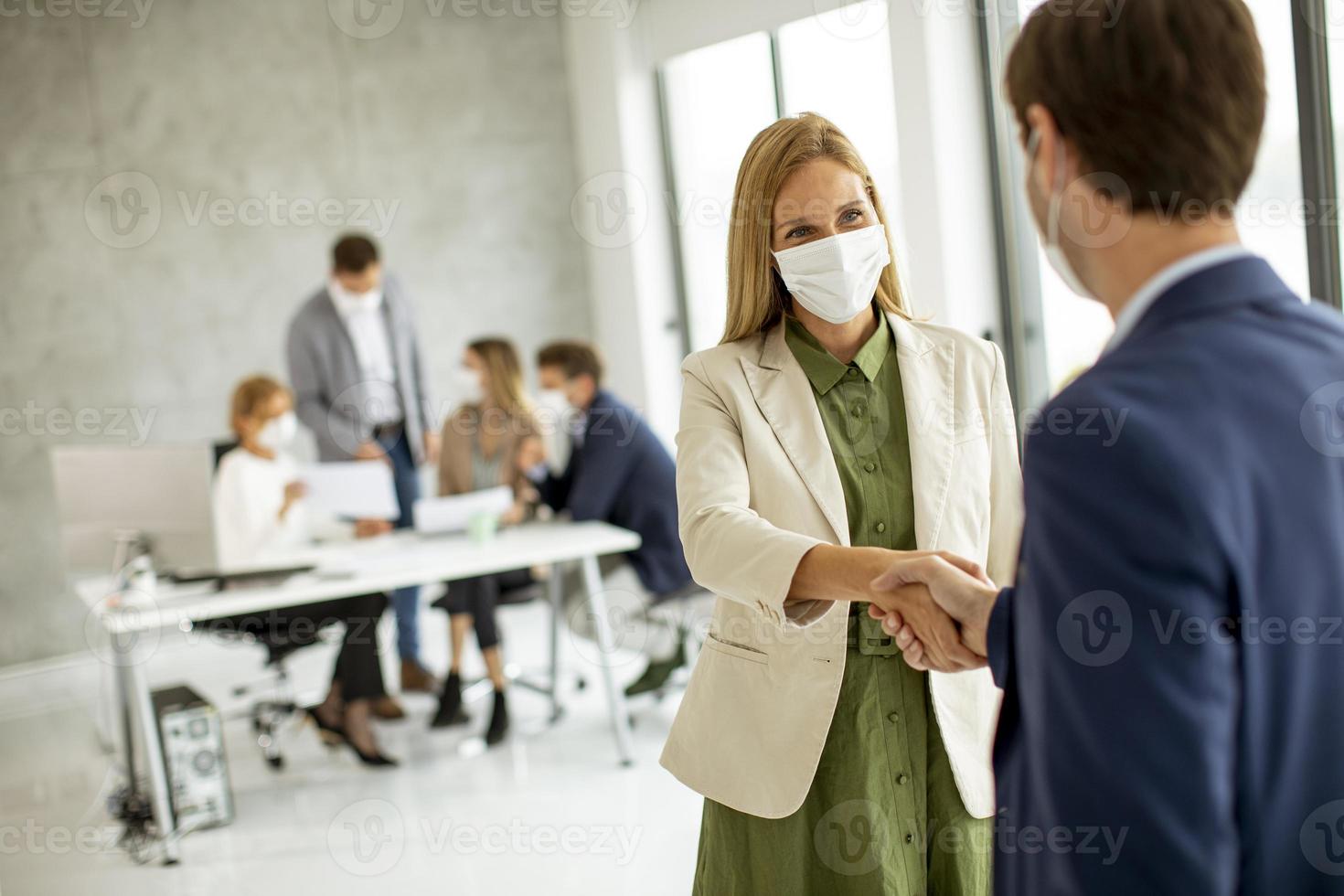 Professionals meeting while wearing masks photo