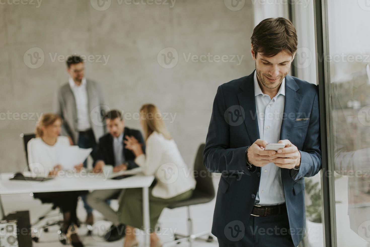 Hombre tomando un descanso con la reunión del equipo en el fondo foto