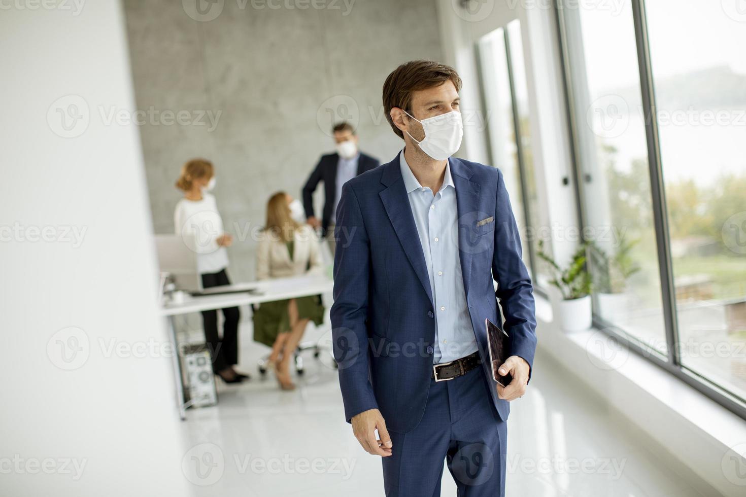 Man standing in front of team with a mask on photo