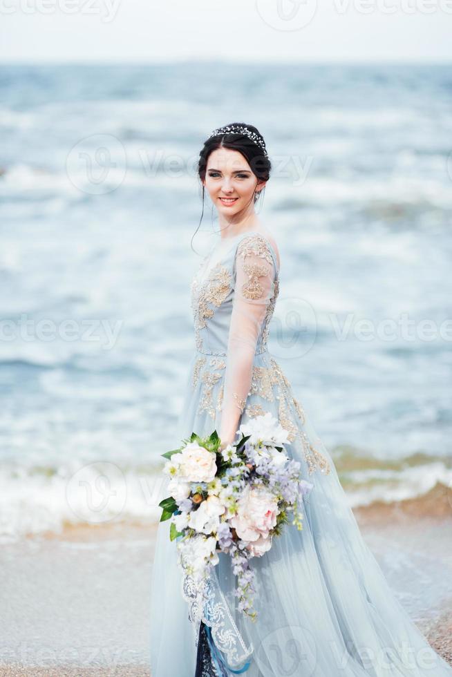 novia con un ramo de flores en la playa foto