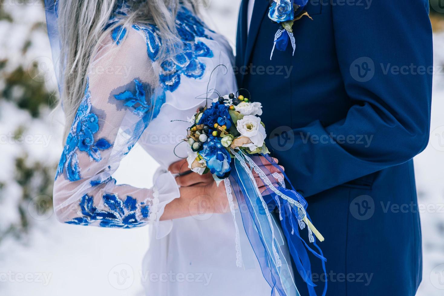 Groom in a blue suit and bride in white in the mountains Carpathians photo