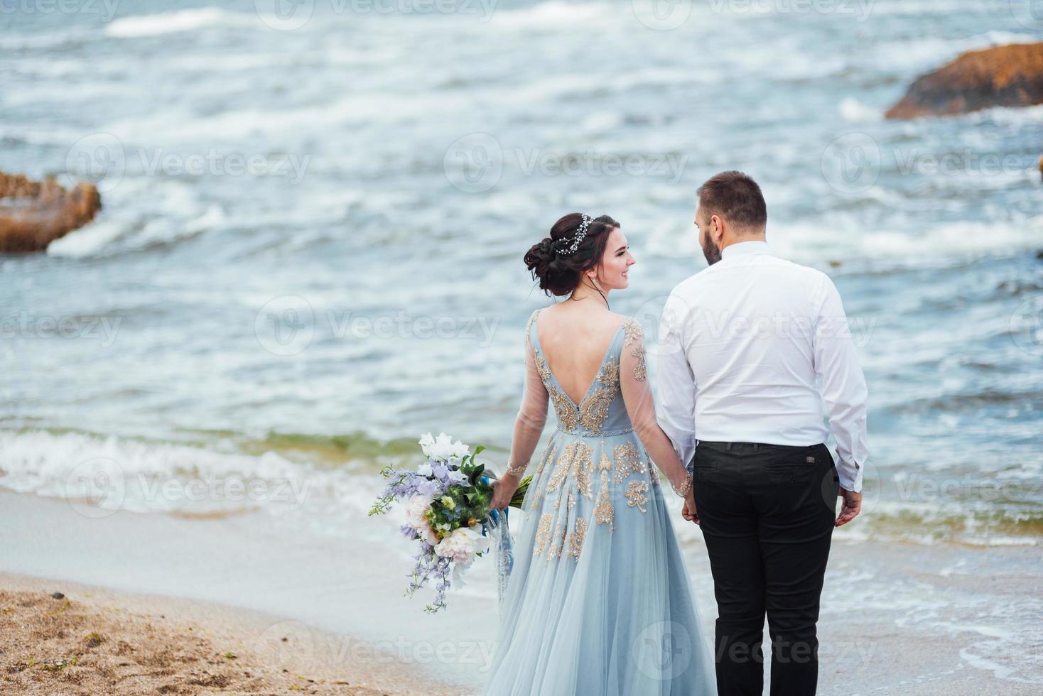 Same couple with a bride in a blue dress walk photo