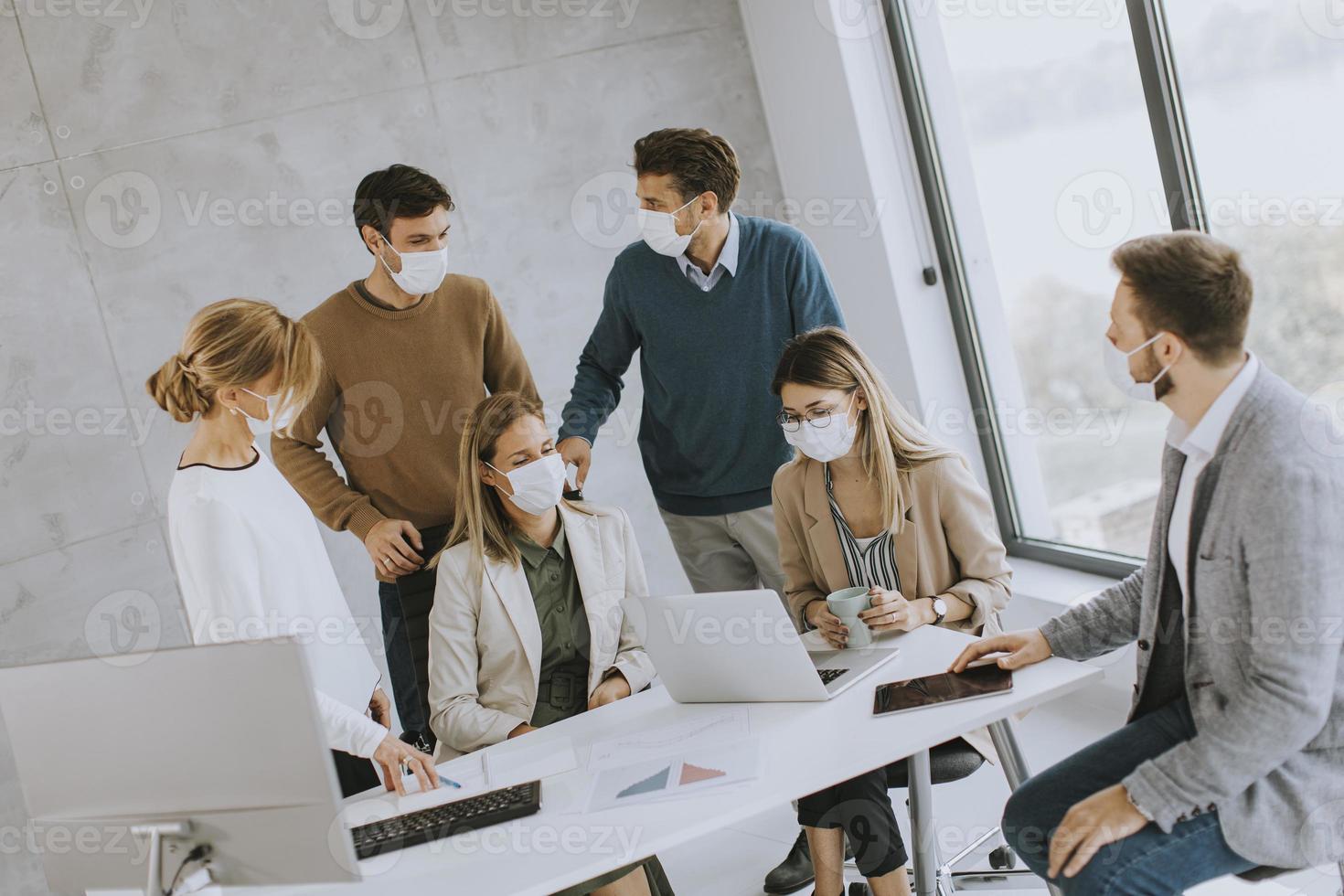 personas enmascaradas en una reunión en una oficina moderna foto