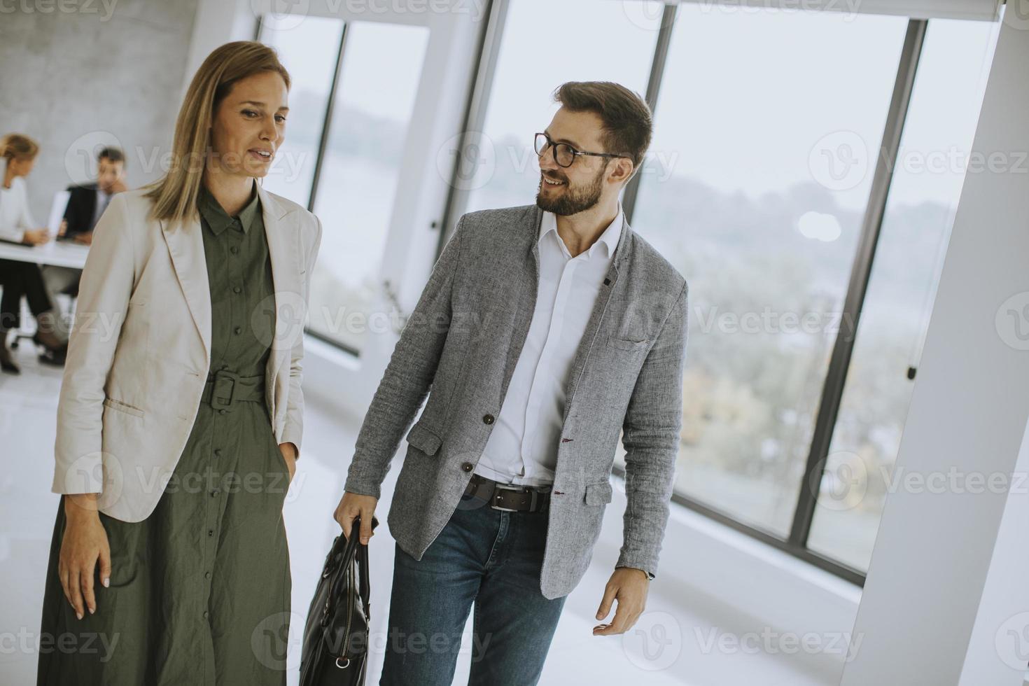 Business couple walking together in office space photo