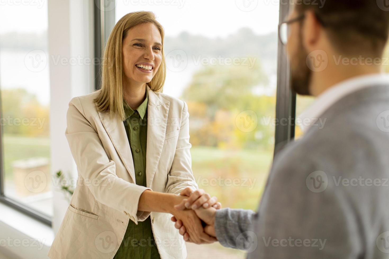 Woman shaking man's hand photo