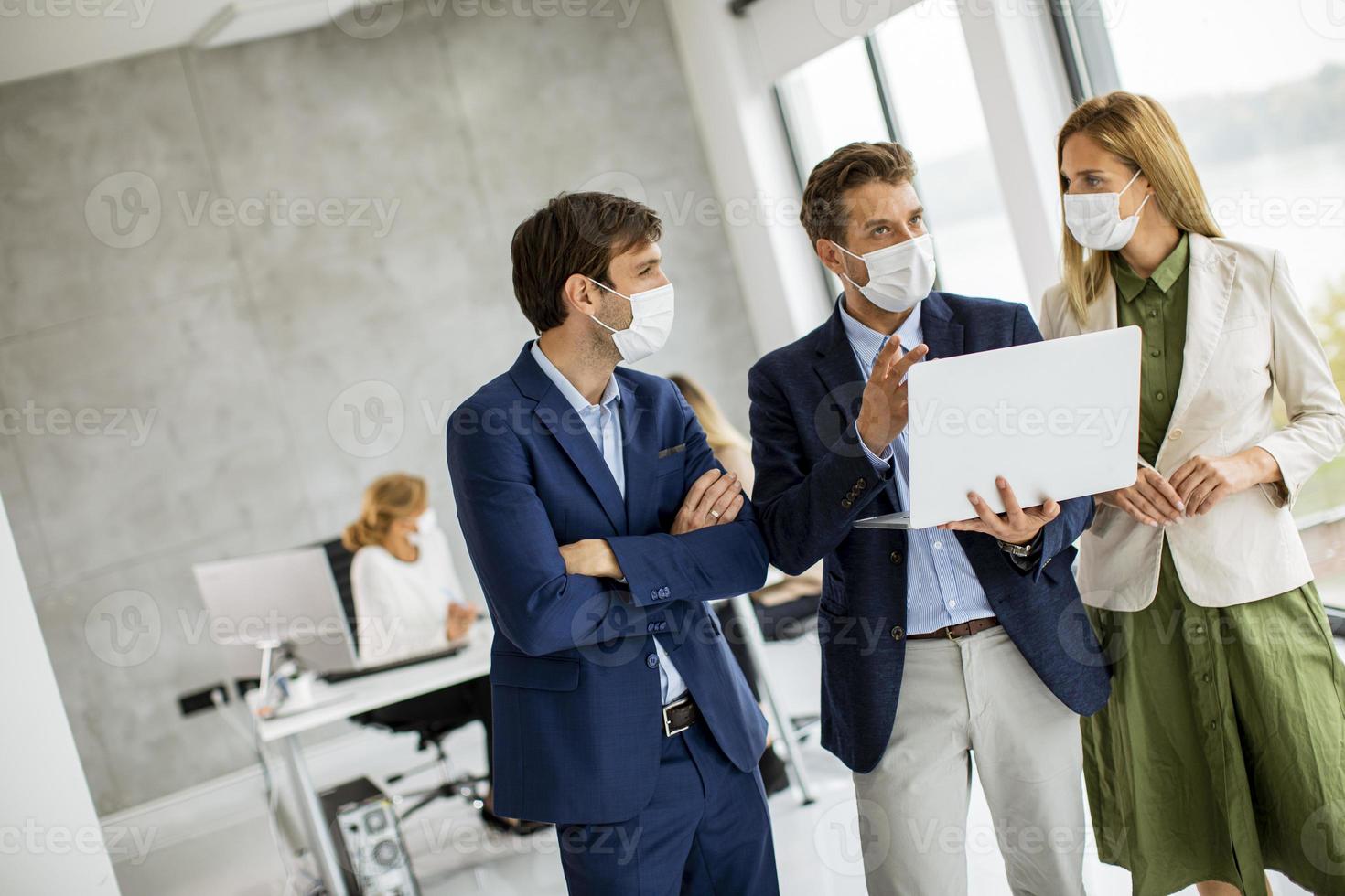 tres profesionales enmascarados en una reunión foto